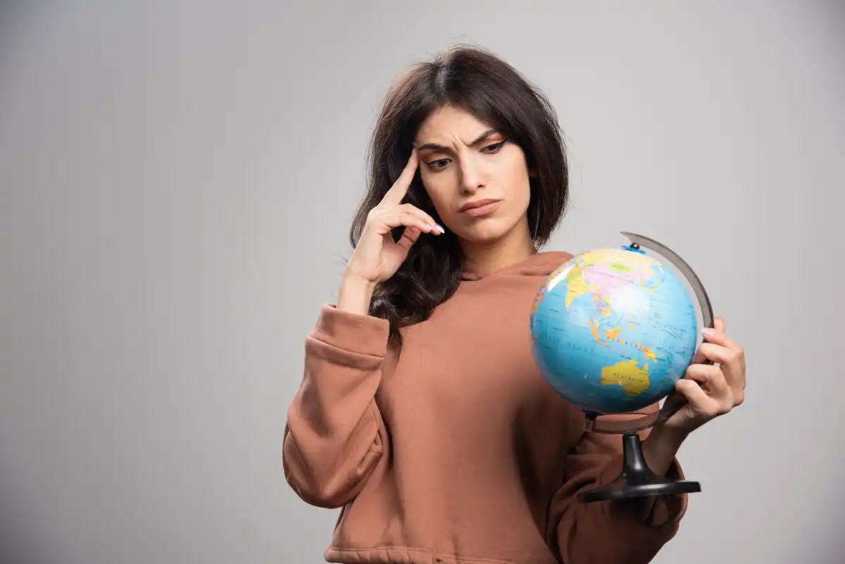 Young woman holding a globe while planning her next travel destination