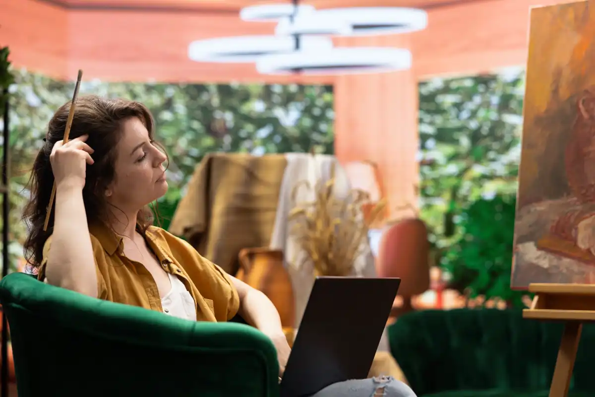 Woman relaxing in a chair and using a laptop at home