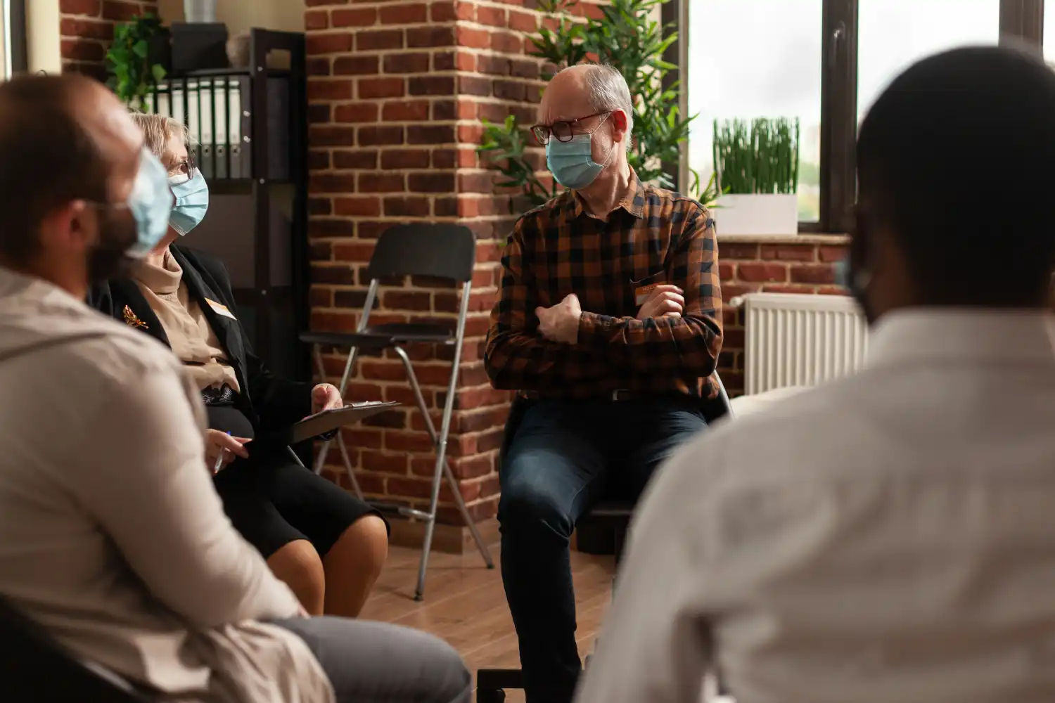 A group of people sitting together while one person speaks during a discussion.